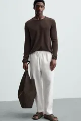 Pantalón negro de lino, corte recto y relaxed fit, con cintura elástica ajustable con cordón, bolsillos laterales y traseros.