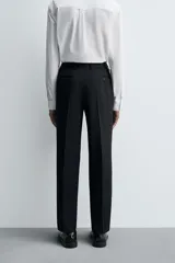 Pantalón de vestir negro de lana, corte recto, con bolsillos laterales y traseros de ojal con botón.