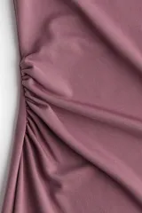 Vestido midi sin mangas color rosa viejo, de punto elástico con leve brillo, corte ajustado y frunces en escote, hombros y en un lateral de la cintura para crear un efecto drapeado.