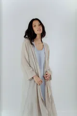 Saco de hilo color beige, de manga larga y tejido calado.