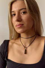 Gargantilla doble con choker de cuero negro y collar con dije de piedra natural marrón en forma de gota con engarce de acero quirúrgico hipoalergénico y tiento negro.