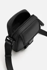 Bandolera vertical negra de acabado engomado con compartimento principal con cierre de cremallera y bolsillo interior plano. Bolsillo frontal con cierre de hebilla de liberación rápida. Asa de hombro ajustable y extraíble.