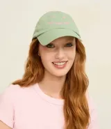 Gorra de béisbol de sarga color verde menta con visera curva. Presenta bordado frontal en hilo rosado con la frase "good days ahead" y pequeños detalles florales.