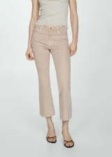 Pantalón de jean color beige, de corte flare, tiro alto y largo crop con terminación desflecada.