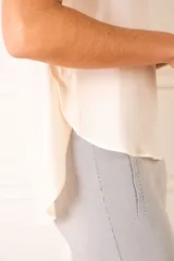 Blusa color crudo de poliéster con mangas cortas y cuello redondo.