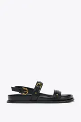 Sandalias planas de cuero negro con dos tiras horizontales sobre el empeine y una tira trasera ajustable con hebilla.