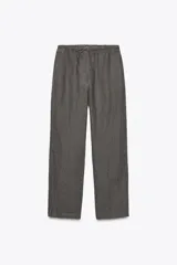 Pantalón de lino gris con cintura ajustable con cordones y bolsillos laterales ocultos.