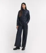 Pantalón pantalona confeccionado en material sintético con pliegues y bolsillos.