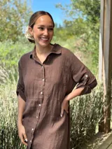 Vestido camisero largo de lino blanco, con corte en la cintura, abertura lateral y botones de nácar.