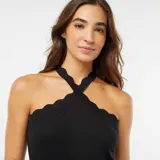 Camiseta de tirantes negra con cuello halter cruzado y detalle de ondas en el escote.