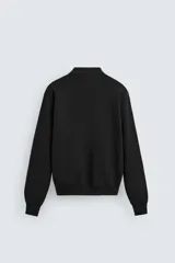 Polo de manga larga color negro, tejido en punto de algodón, corte relaxed fit, cuello solapa y cierre frontal con botonadura.