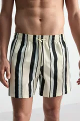 Short de baño blanco con rayas verticales negras y celestes, cintura elástica con cordón ajustable, bolsillos laterales y trasero.