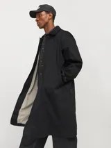 Tapado negro de corte recto, con cuello clásico, cierre frontal con botones ocultos y bolsillos laterales.