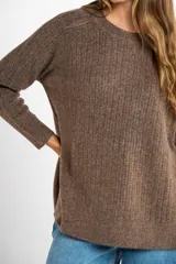 Sweater color beige de tejido texturado, con cuello redondo y mangas largas.