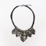 Collar corto con cordones negros y apliques metálicos plateados con forma de hojas.