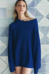 Sweater azul de tejido de punto acanalado, con cuello redondo amplio y mangas largas.