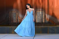 Vestido largo celeste con breteles finos con detalle de cadena, escote en V y corte imperio con falda escalonada.