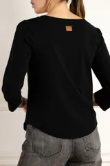 Remera negra de mangas 3/4, corte ajustado y escote redondo.