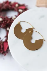 Aros circulares de acero quirúrgico con baño de oro de 18k. Diseño con forma geométrica y cierre de gancho. Diámetro de 4cm.