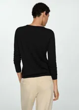 Sweater de punto fino color beige, con cuello redondo y mangas largas.