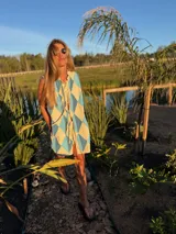 Camisa vestido con estampado de rombos en tonos celeste y blanco, con cuello camisero y lazo en el escote.