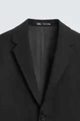 Blazer slim fit negra confeccionada en tejido con viscosa. Cuello con solapas de muesca. Manga larga acabada en puño con detalle de botones. Bolsillo de vivo en pecho y de solapa en cadera. Detalle bolsillo interior. Bajo con aberturas en espalda. Cierre frontal con botones.
