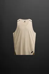 Musculosa deportiva color beige de tejido técnico ligero y elástico con estructura perforada. Tiene cuello redondo amplio, manga sisa con acabados termofijados, bajo con aberturas laterales y logo estampado.