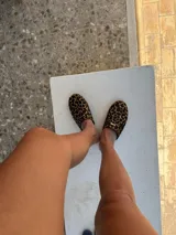 Slippers con estampado animal print, forro y plantilla de cuero negro.