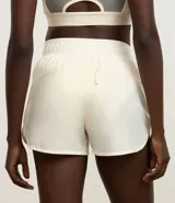 Short deportivo femenino color blanco, de poliéster, con cintura elástica, abertura lateral y bolsillo trasero.