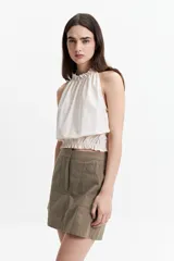Blusa sin mangas color ladrillo, con cuello halter y elástico en el cuello y la cintura.