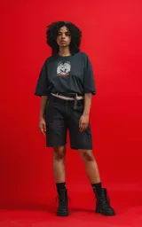 Remera negra de algodón con cuello redondo y calce oversize. Estampado frontal con diseño de calavera con sombrero de copa y personajes de Disney.