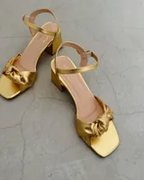 Sandalia plateada de cuero vacuno con taco cuadrado de 6 cm y tira delantera con nudo.