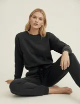 Pantalón jogger negro de corte deportivo, con pretina ancha elastizada y lazo de ajuste. Presenta dos bolsillos delanteros y puños elastizados en los tobillos.