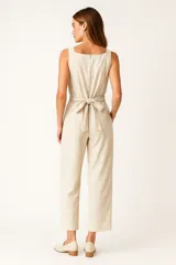 Mono de viscosa color verde oliva, con breteles anchos, corte holgado, cierre lateral y cuello recto. Diseño a rayas verticales.