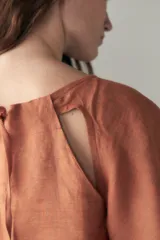 Top color ladrillo de cuello halter y manga corta con efecto cut-out en la sisa y tajos laterales.
