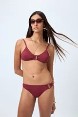 Bottom de bikini negro con textura y detalle de aro en uno de los laterales.