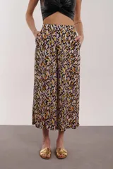 Pantalón de tiro alto con estampado en tonos negro y lila, con corte amplio y bolsillos laterales.