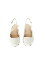 Zapato de tacón destalonado color blanco con textura de piel de serpiente. Tiene punta cuadrada, tira trasera ajustable y tacón bajo.