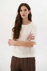 Blusa color crudo de lino con cuello redondo y mangas cortas.