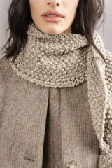 Bufanda tejida a mano en punto arroz color beige, con pompones en los extremos.