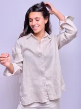 Camisa rosada de lino con cuello clásico, cierre frontal con botones, mangas largas con puños abotonados y logo bordado en el pecho.