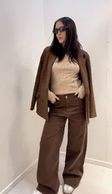 Blazer marrón de gamuza sintética, con solapas de muesca, doble botonadura y forro interior.