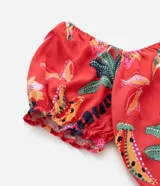 Blusa plus size con mangas cortas abullonadas y elástico en los hombros. Prenda confeccionada en viscolino y estampada con motivos de follajes y tucanes.
