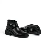 Bota corta de cuero color marrón con cierre lateral, suela de goma negra y hebilla decorativa.