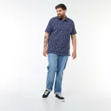 Chomba azul marino de piqué con estampado de palmeras y tablas de surf blancas.