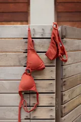 Conjunto de bikini turquesa con textura acanalada, compuesto por un corpiño triangular con argolla central y una bombacha vedetina con argollas en los laterales.