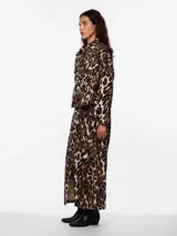 Camisa animal print con estampado de leopardo en tonos marrones y beige. Tiene cuello camisero, mangas largas con puños abotonados, cierre frontal con botones y dos bolsillos de parche en el pecho.