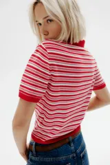 Remera polo de punto fino suave, a rayas horizontales rojas y blancas. Modelo entallado de manga corta con cuello y tapeta de botones.