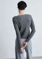 Sweater gris de punto canalé con cuello barco y mangas largas.