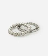 Set de dos pulseras plateadas de metal. Una de esferas de diferentes tamaños y otra de eslabones tipo cadena con cierre de mosquetón.